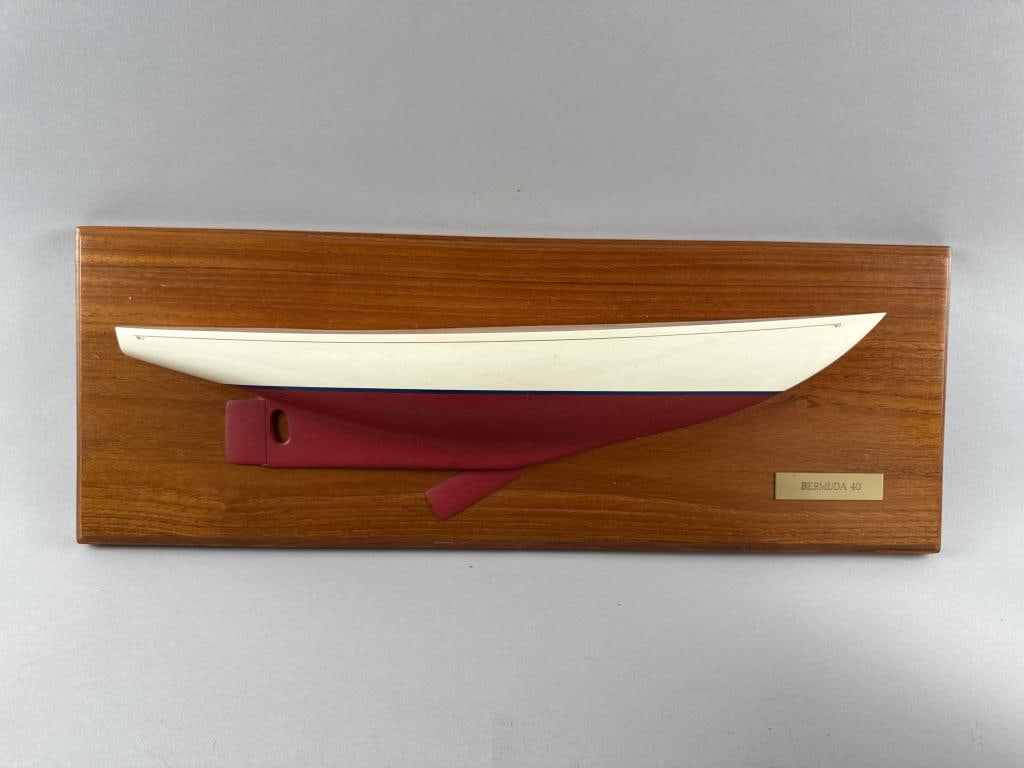 TRIDENT STUDIOS MOUNTED HALF HULL MODEL OF A BERMUDA 40 America, Contemporary Backboard 8.5" x: TRIDENT STUDIOS MOUNTED HALF HULL MODEL OF A BERMUDA 40 America, Contemporary Yacht type identified on a brass plaque affixed to backboard. Backboard 8.5" x 24.5".