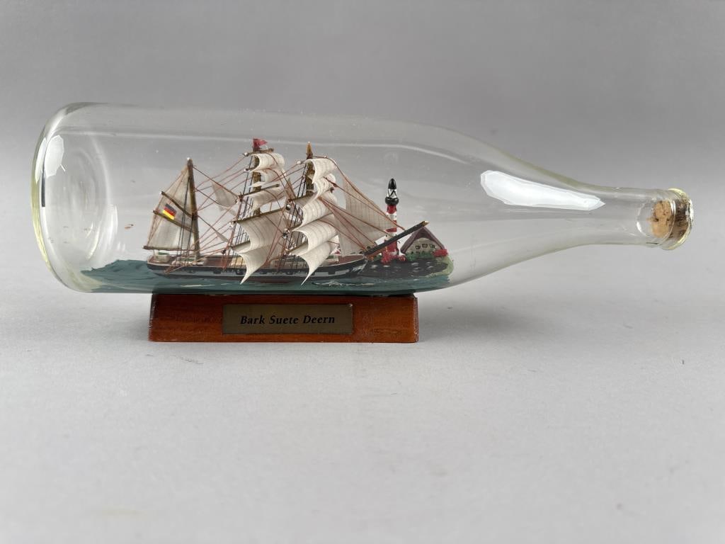 SHIP IN A BOTTLE OF THE BARK "SUETE DEERN" 20th Century Height 4.25". Length 10.75".: SHIP IN A BOTTLE OF THE BARK "SUETE DEERN" 20th Century Bottle resting on a wooden cradle. Height 4.25". Length 10.75".