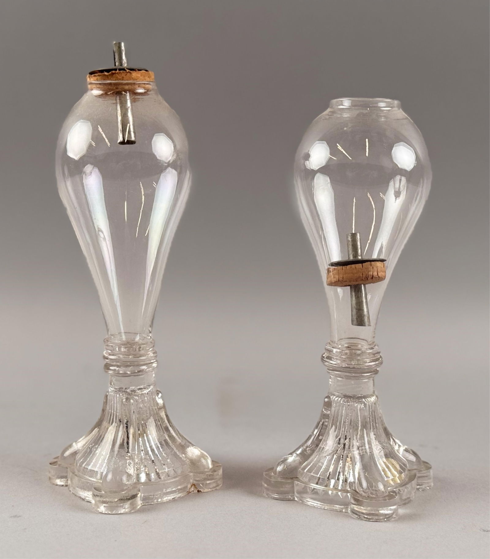 PAIR OF PRESSED AND FREE-BLOWN CLEAR GLASS LAMPS First Half of the 19th Century Heights 7".: PAIR OF PRESSED AND FREE-BLOWN CLEAR GLASS LAMPSFirst Half of the 19th CenturyBoth with original tin burners.Heights 7". Provenance:William Dixon Collection.