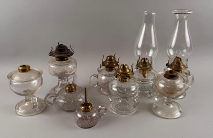 NINE CLEAR GLASS FLUID HAND LAMPS Late 19th/Early 20th Century Heights excluding chimneys from 3" to
