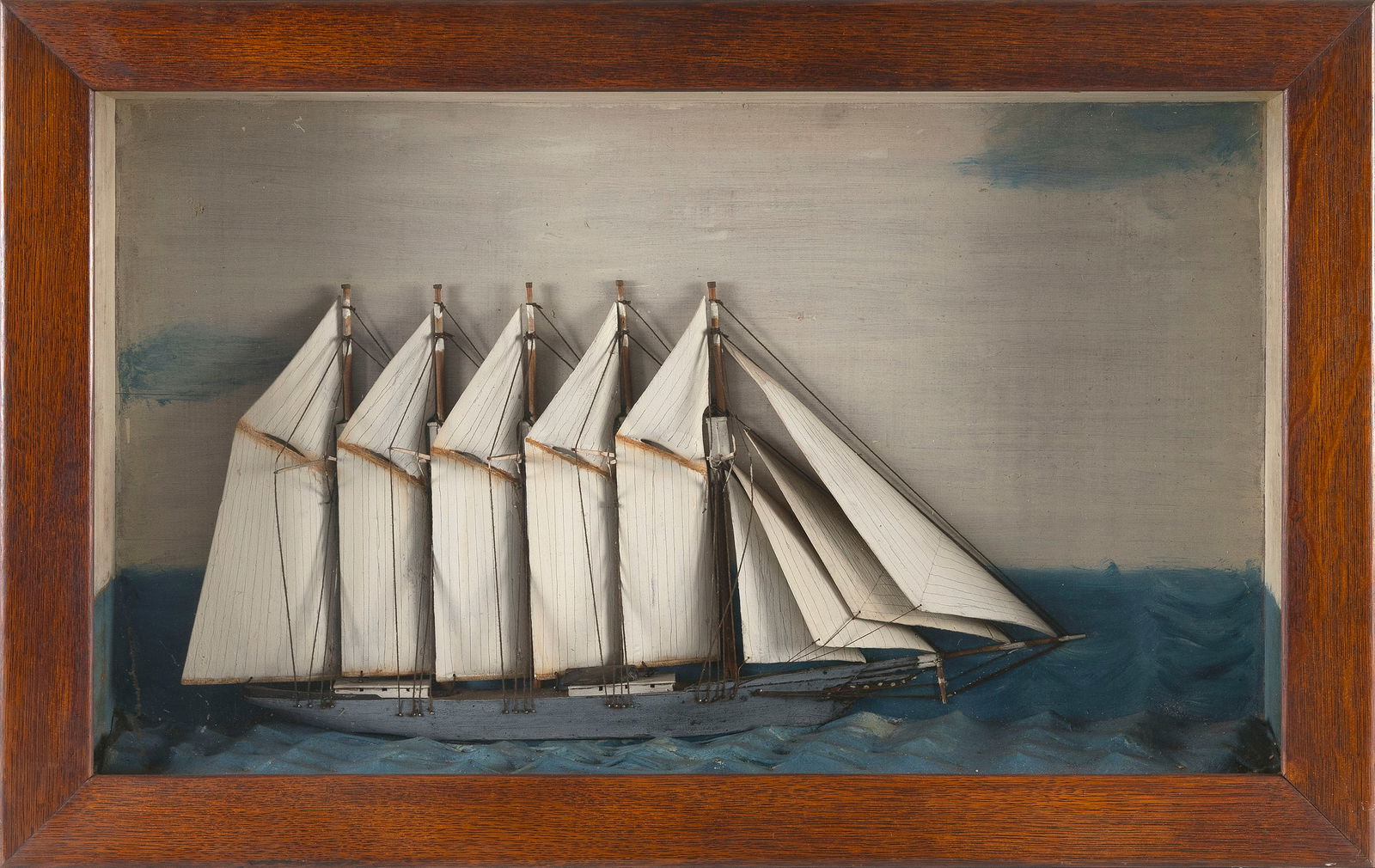 DIORAMA MODEL OF A FIVE-MASTED COASTAL SCHOONER, MADE BY CAPTAIN ISRAEL BAKER, SR. OF CAPE COD Circa: DIORAMA MODEL OF A FIVE-MASTED COASTAL SCHOONER, MADE BY CAPTAIN ISRAEL BAKER, SR. OF CAPE CODCirca 1885Schooner set in a molded sea against a painted sea and sky background. Hand-carved sails. Housed