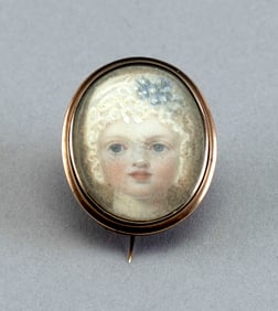 PORTRAIT MINIATURE OF A CHILD SET WITHIN A GOLD BROOCH Mid-19th Century 1" x .75".