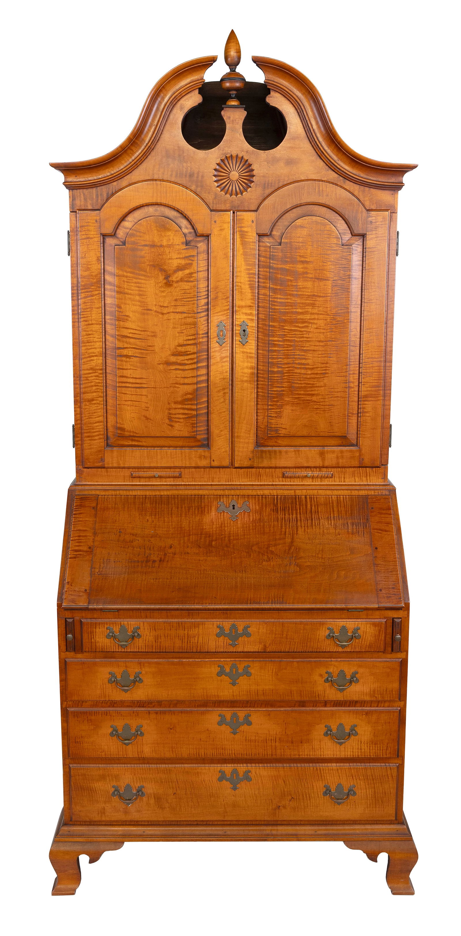 ELDRED WHEELER TIGER MAPLE BONNET-TOP SECRETARY Massachusetts, 20th Century Height 89". Width 35".: ELDRED WHEELER TIGER MAPLE BONNET-TOP SECRETARYMassachusetts, 20th CenturyIn two parts. Upper case with a broken arch pediment centering a finial, a carved sunburst and two arched paneled doors. Lower