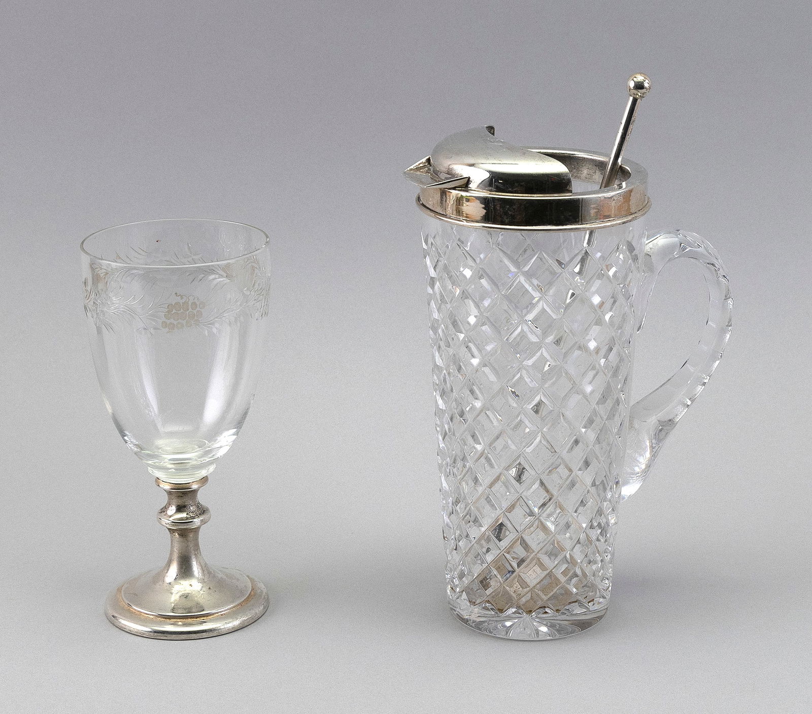 TWO PIECES OF HAWKES BARWARE 20th Century: TWO PIECES OF HAWKES BARWARE20th Century1) Sterling silver-mounted cut glass cocktail pitcher with silver stirrer. Height 9". 2) Wine goblet with etched fruit and vine decoration around the rim, and a