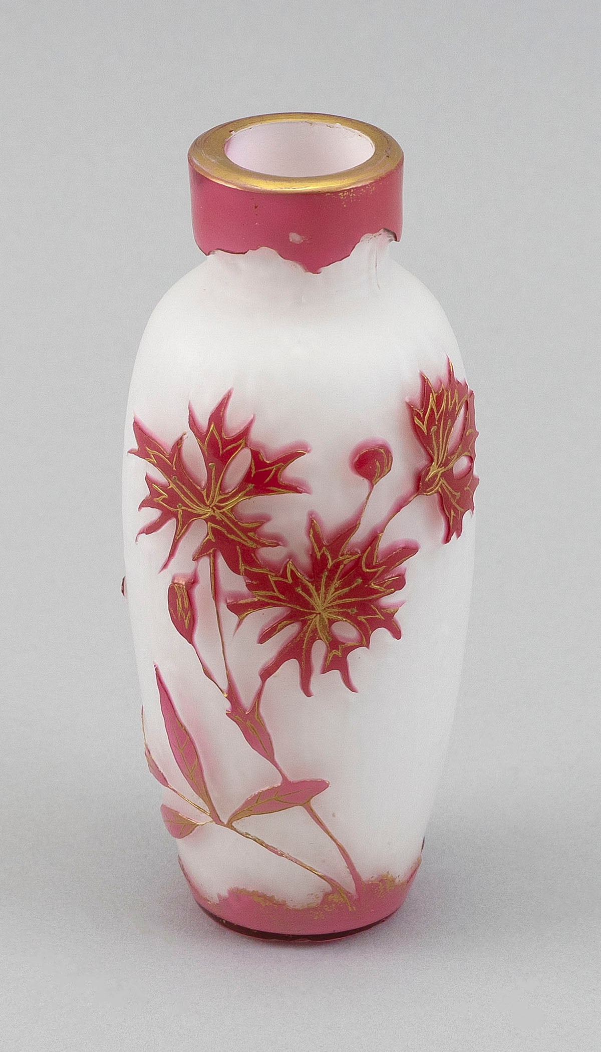 CAMEO GLASS VASE ATTRIBUTED TO DAUM NANCY France, Late 19th/Early 20th Century Height 5.5". Rim: CAMEO GLASS VASE ATTRIBUTED TO DAUM NANCYFrance, Late 19th/Early 20th CenturyCranberry cut to opalescent white floral design, with gilt embellishments. Unsigned.Height 5.5". Rim diameter 1.375". Prove