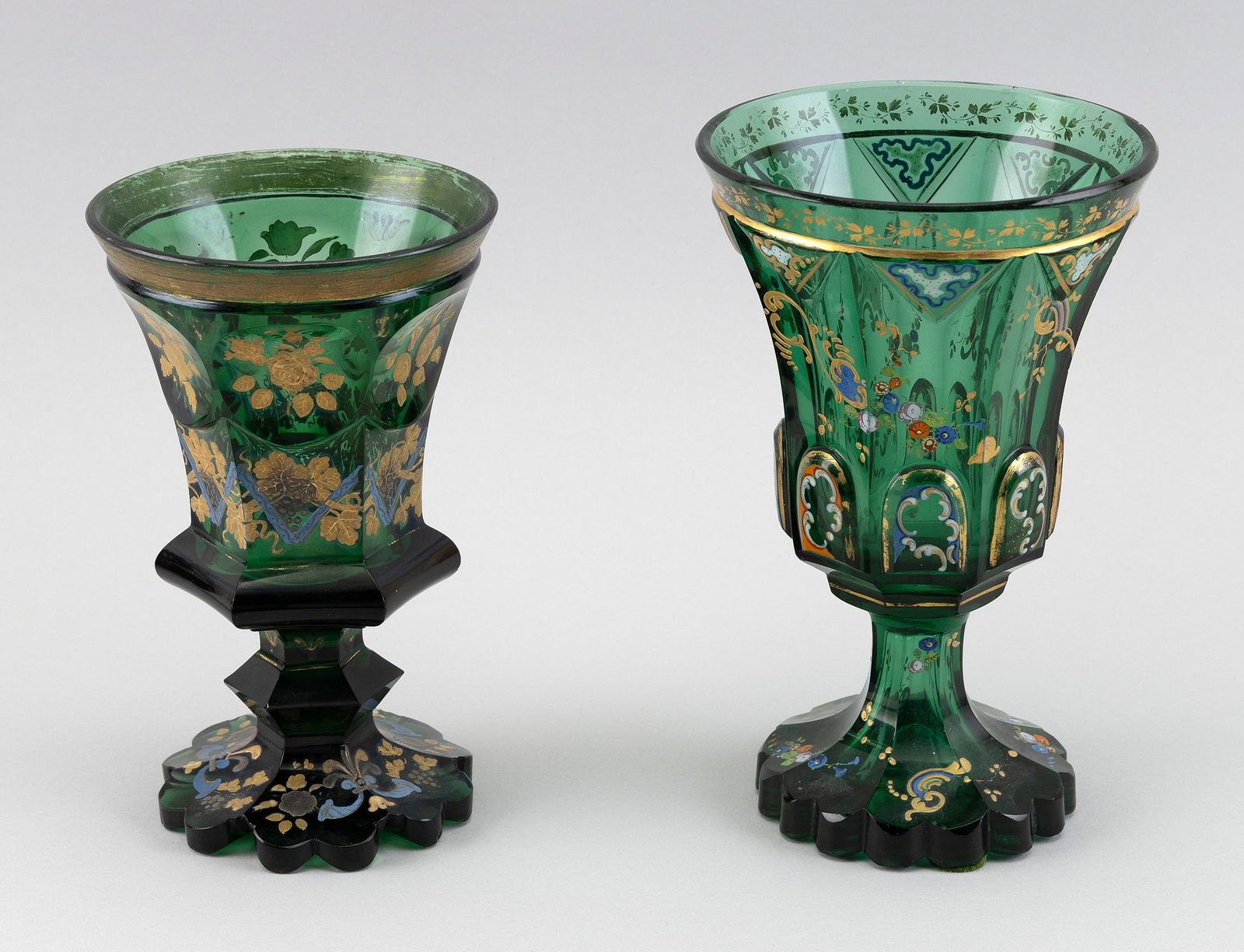 TWO BOHEMIAN BIEDERMEIER CUT AND ENAMELED GREEN GLASS POKALS Mid-19th Century Heights 7.25" and 8".: TWO BOHEMIAN BIEDERMEIER CUT AND ENAMELED GREEN GLASS POKALSMid-19th CenturyBoth with gilt embellishments.Heights 7.25" and 8". Provenance:The Estate of Harold Smalley, Osterville, Massachusetts.</