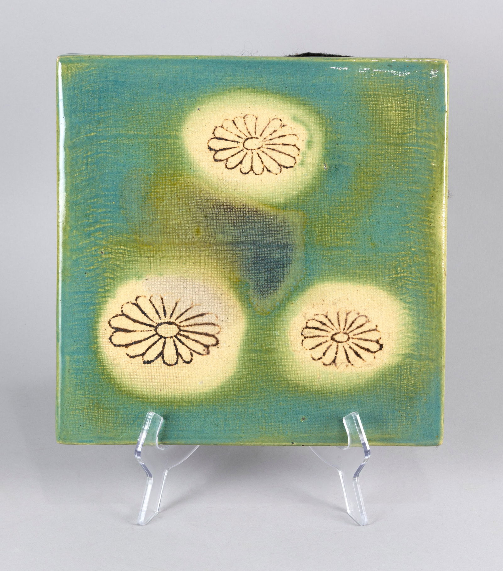 JAPANESE TEA CEREMONY ORIBE POTTERY TILE Late Meiji/Early Taisho Period Height 1". Length 11". Width: JAPANESE TEA CEREMONY ORIBE POTTERY TILELate Meiji/Early Taisho PeriodDecoration of three chrysanthemum mons against a green ground. Incised scroll decoration about the edges.Height 1". Length 11". Wi