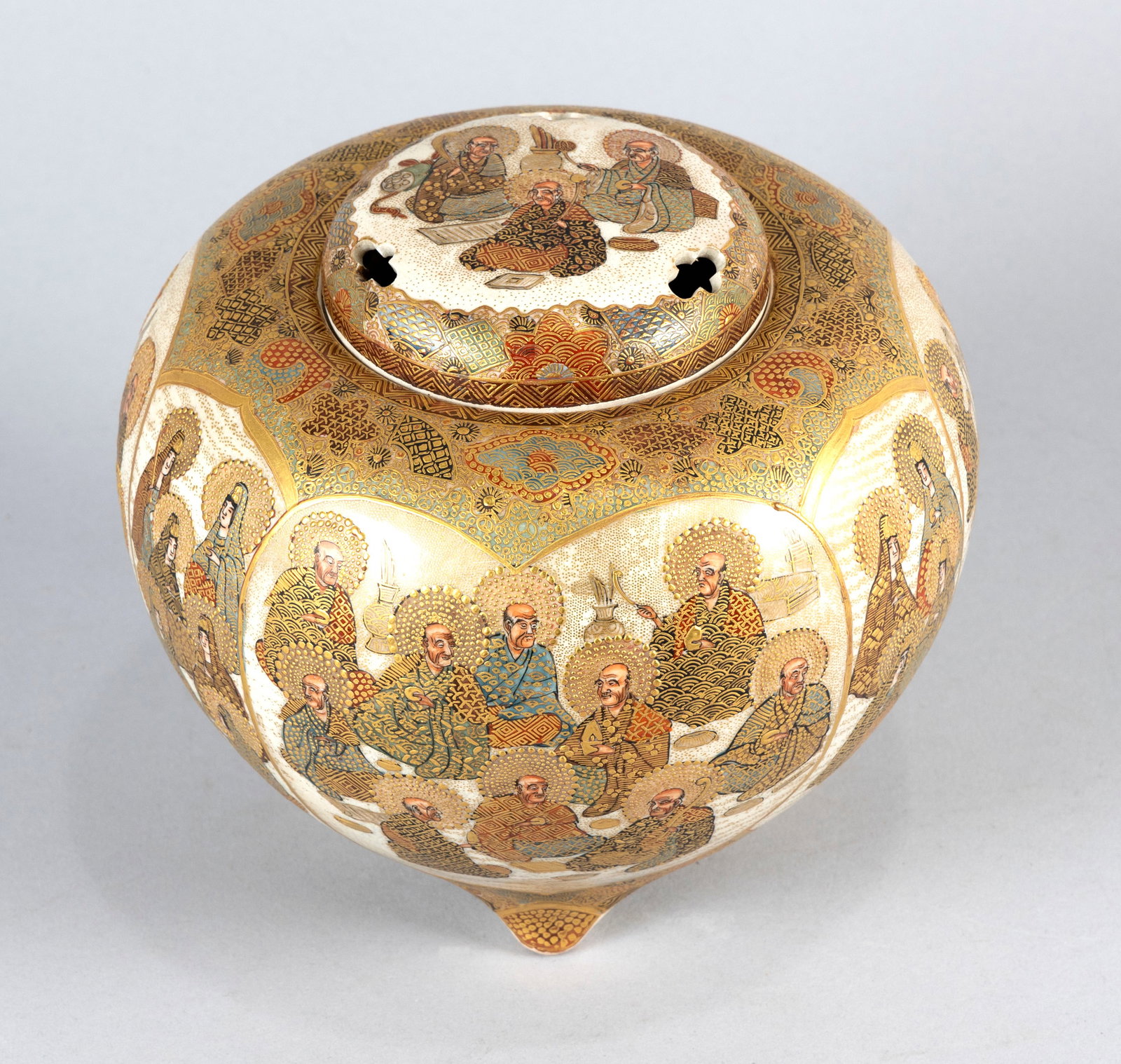 JAPANESE SATSUMA PORCELAIN CENSER Meiji Period Height 6.5". Diameter 7".: JAPANESE SATSUMA PORCELAIN CENSER Meiji Period Globular body on three stump feet. Decorated with mihrab-form panels filled with finely executed Thousand Lohan vignettes against a highly detailed gilt 