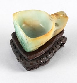 CHINESE CELADON JADE COUPE 19th Century Height 1.25". Length 2.5". With carved wood stand.