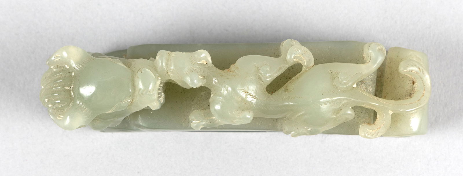 CHINESE LIGHT CELADON JADE BRUSH REST OR GIRDLE HOOK Late 19th/Early 20th Century Height 1.25".: CHINESE LIGHT CELADON JADE BRUSH REST OR GIRDLE HOOKLate 19th/Early 20th CenturyIn the form of a dragon and its young.Height 1.25". Length 4".