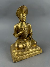 TIBETAN GILT BRONZE FIGURE OF A SEATED GURU Late 19th/Early 20th Century Height 7". Width 4".