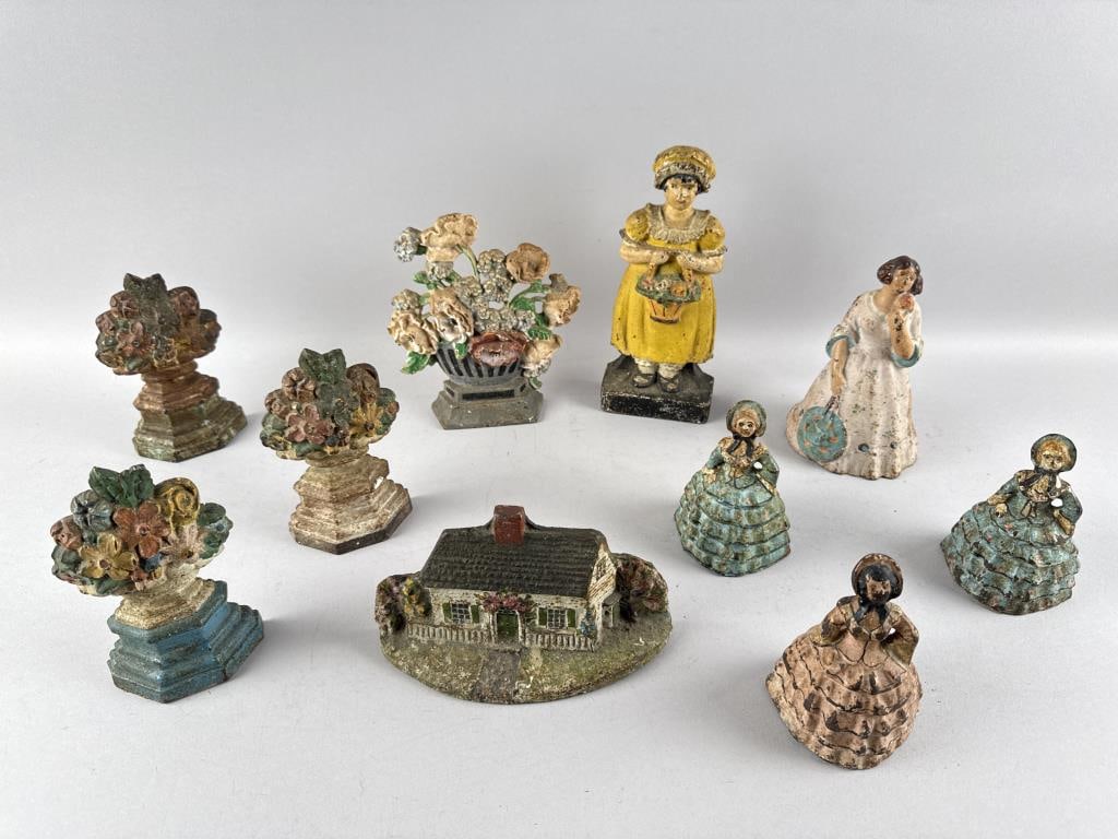 TEN CAST IRON DOORSTOPS 20th Century Heights from 4.5" to 9".: TEN CAST IRON DOORSTOPS20th CenturyFour flower baskets, one cottage, one woman with a flower basket, one woman with a fan, and three Southern belles.Heights from 4.5" to 9".