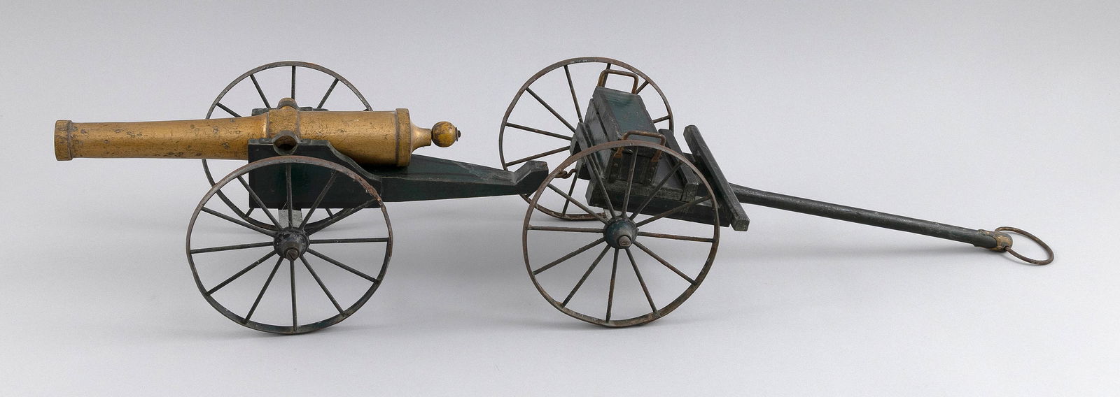 TOY CANNON, LIMBER AND CAISSON Early 20th Century Cannon length 9.5".: TOY CANNON, LIMBER AND CAISSONEarly 20th CenturyGreen and gold painted wood with white metal wheels and fittings.Cannon length 9.5".