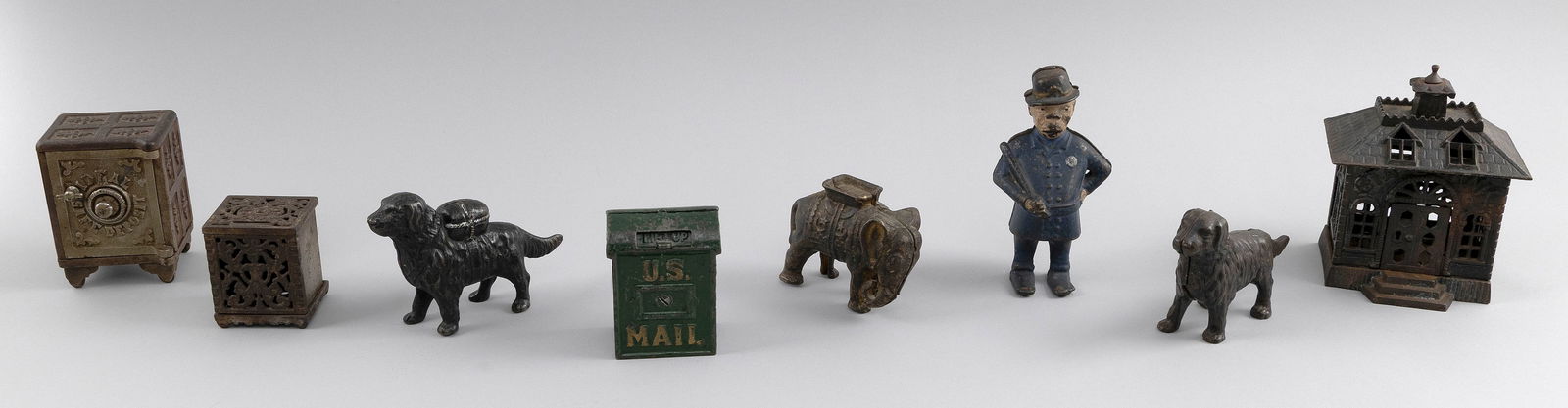 EIGHT CAST IRON STILL BANKS 19th/20th Century Heights from 3" to 6".: EIGHT CAST IRON STILL BANKS19th/20th CenturyA policeman, a U.S. mailbox, two dogs, an elephant, a safe, a box and a State Bank.Heights from 3" to 6".