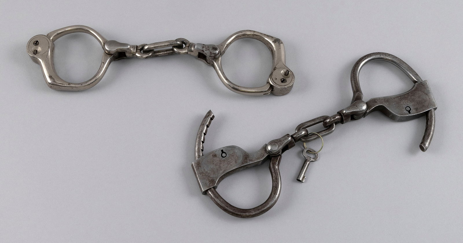 TWO PAIRS OF POLICE HANDCUFFS 19th/Early 20th Century: TWO PAIRS OF POLICE HANDCUFFS19th/Early 20th Century1) Stamped "Tower's". Includes key. Length 9.5". 2) Cobb "Bean" cuffs. Marked with patent date of May 2, 1899. No key. Lengths 10".