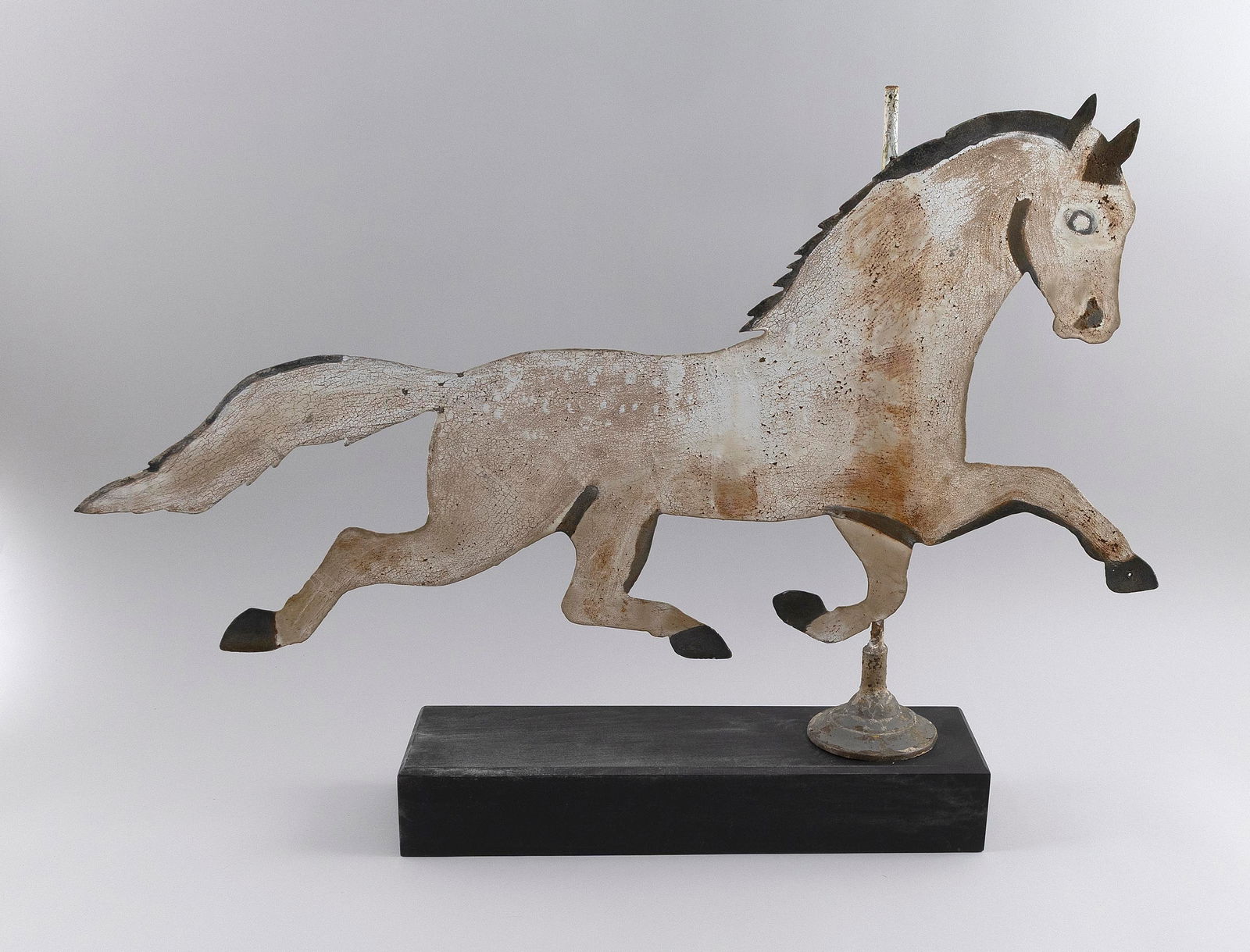 SHEET METAL HORSE WEATHER VANE 20th Century Total height 23". Length 32".: SHEET METAL HORSE WEATHER VANE20th CenturyIn early crusty paint. Mounted on a wooden base painted black.Total height 23". Length 32".
