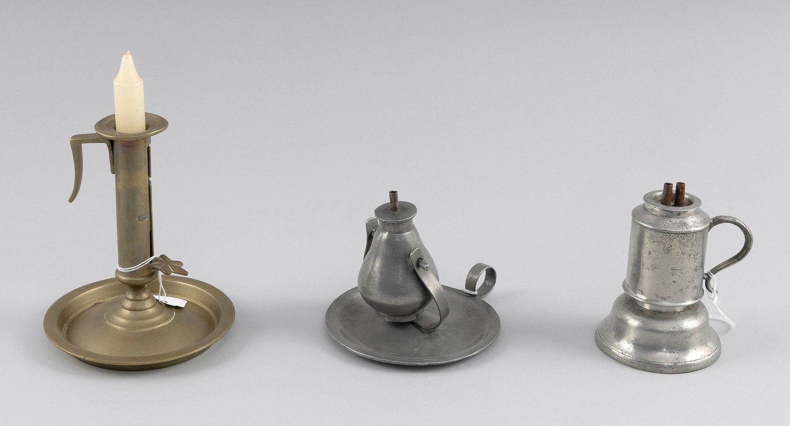 TWO PEWTER LAMPS AND AN ADJUSTABLE BRASS CANDLESTICK England and America, 19th Century Heights from (1 of 3)