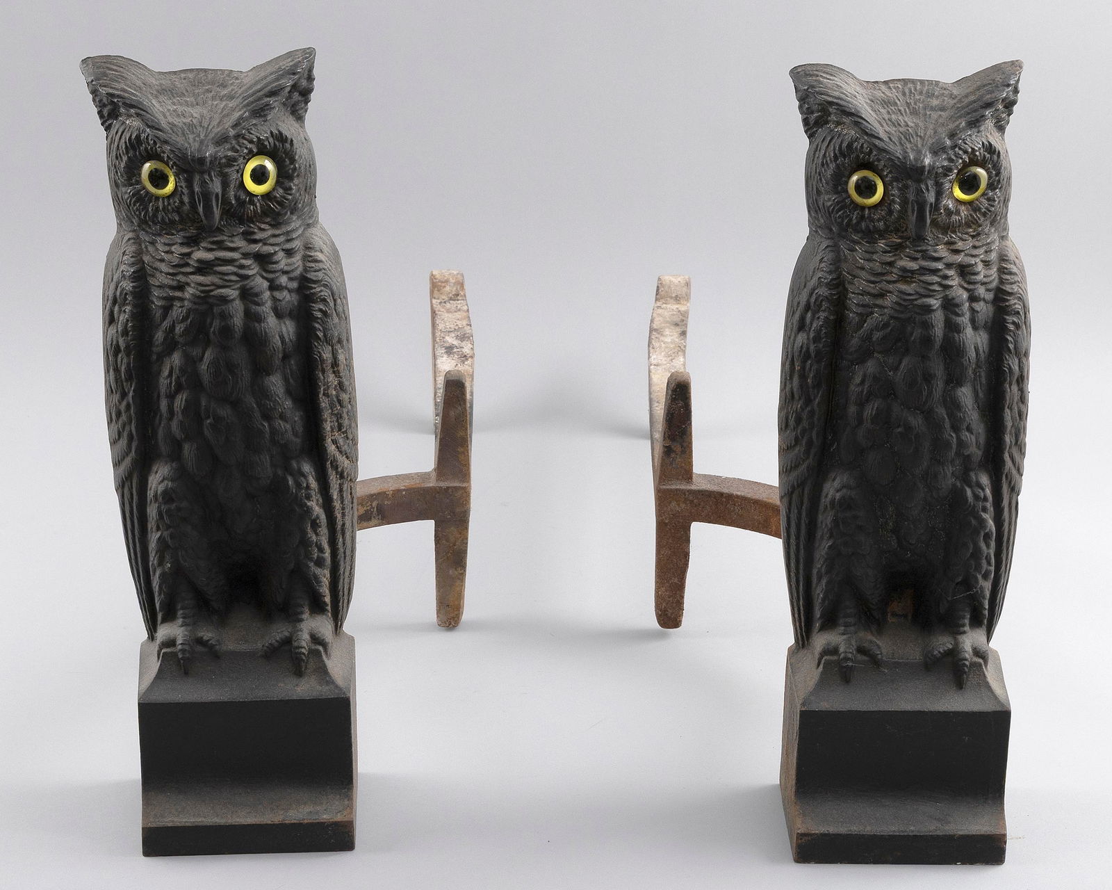 PAIR OF CAST IRON OWL ANDIRONS ATTRIBUTED TO HUBLEY Early 20th Century Heights 16".: PAIR OF CAST IRON OWL ANDIRONS ATTRIBUTED TO HUBLEYEarly20th CenturyInset glass eyes. Unmarked but these have been cited as being by Hubley. Four digit number (7040?) cast on the reverse, see photo.He