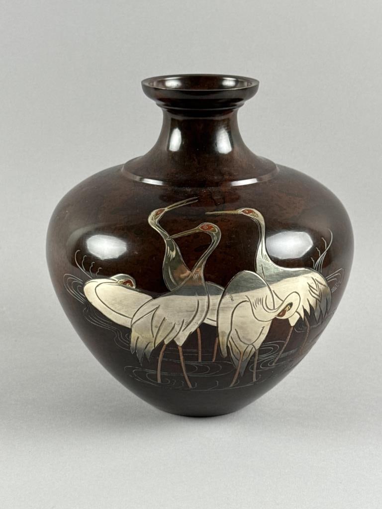 JAPANESE BRONZE AND MIXED METAL OVOID VASE 20th Century Height 9".: JAPANESE BRONZE AND MIXED METAL OVOID VASE20th CenturyDecoration of five silver cranes with gold beaks within a landscape. Signed on base.Height 9".