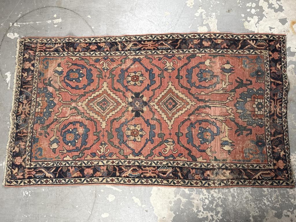 HAMADAN RUG: 6'2" X 3'7" Early 20th Century: HAMADAN RUG: 6'2" X 3'7"Early 20th CenturySpiraling blue and gold vines flank geometric medallions and bold tan, red and blue blossoms on a faded red field. Stylized branches and blossoms decorate a m