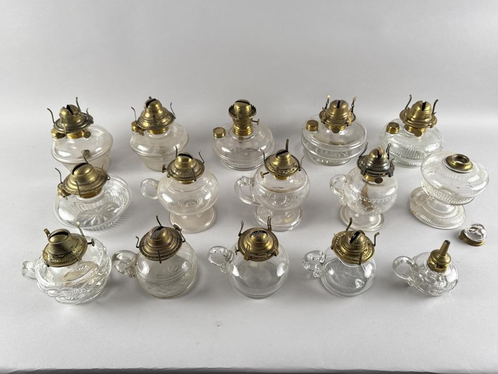 FIFTEEN GLASS FLUID LAMPS Late 19th/Early 20th Century Heights from 5" to 6.5".: FIFTEEN GLASS FLUID LAMPSLate 19th/Early 20th CenturyMostly finger lamps. All but one with original brass burners.Heights from 5" to 6.5".