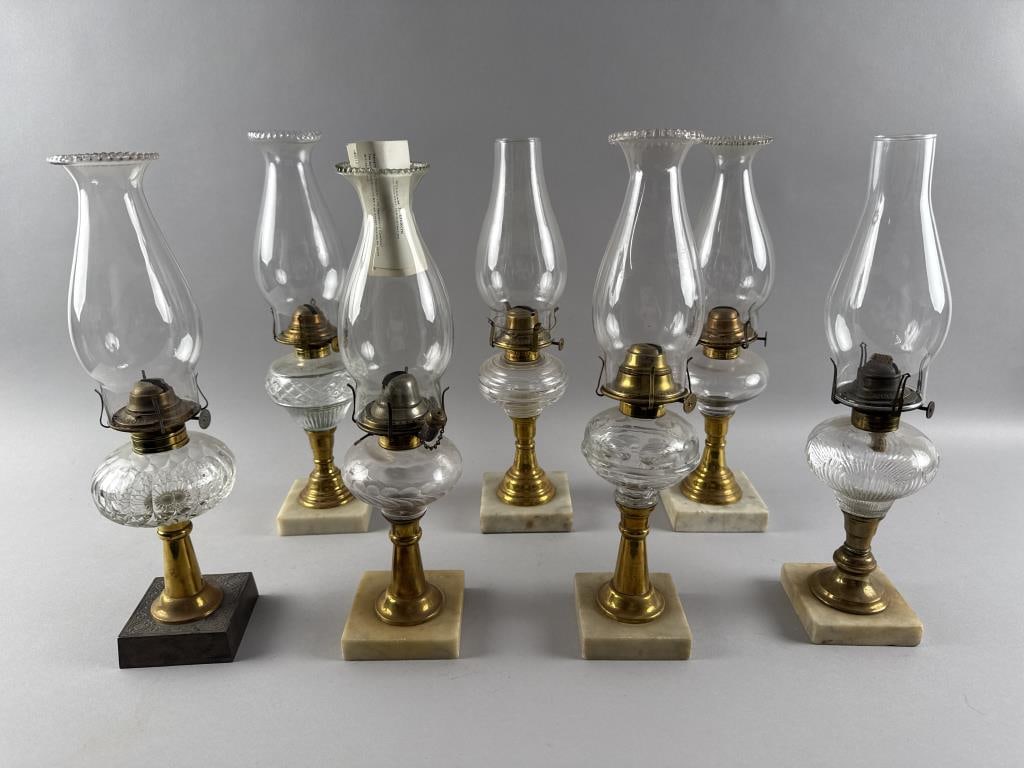 SEVEN BRASS FLUID LAMPS WITH PATTERN GLASS FONTS Late 19th/Early 20th Century Heights approx. 16".: SEVEN BRASS FLUID LAMPS WITH PATTERN GLASS FONTSLate 19th/Early 20th CenturySix with white marble feet and one with an iron foot.Heights approx. 16".