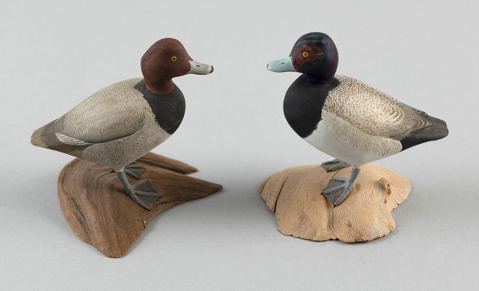 TWO HAROLD GIBBS MINIATURES Barrington, Rhode Island, 1886-1970 Heights 3".: TWO HAROLD GIBBS MINIATURESBarrington, Rhode Island, 1886-1970A redhead drake and a bluebill drake, circa 1960. Both mounted on driftwood bases. One signed "H. Gibbs" the other "HG".Heights 3".