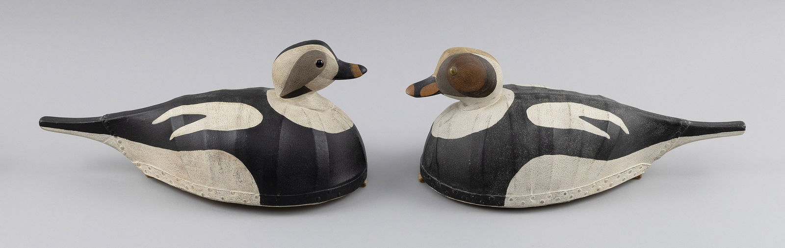 TWO MARTY COLLINS CANVAS-COVERED OLDSQUAW DRAKE DECOYS East Wareham, Massachusetts, 1960- Lengths: TWO MARTY COLLINS CANVAS-COVERED OLDSQUAW DRAKE DECOYSEast Wareham, Massachusetts, 1960-One with glass eyes and one with tack eyes. Branded on undersides.Lengths 15".