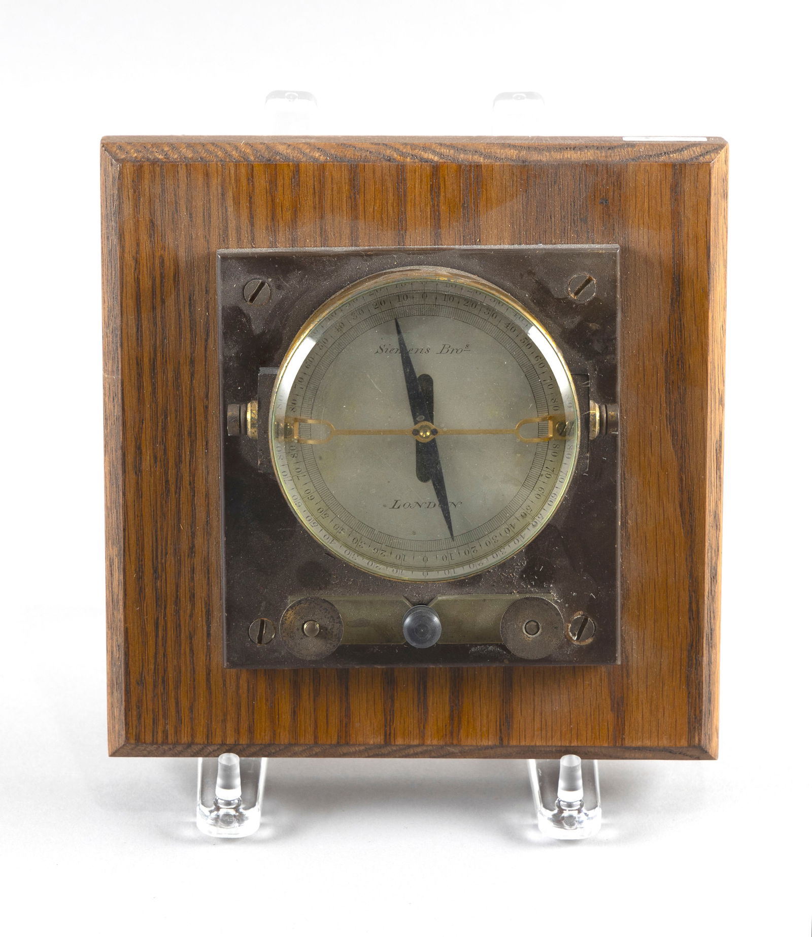 SIEMENS BROS. ASTATIC GALVANOMETER London, Late 19th/Early 20th Century Total height 3.5". Length: SIEMENS BROS. ASTATIC GALVANOMETER London, Late 19th/Early 20th CenturySilvered dial with engraved maker's mark. Mounted on an oak base.Total height 3.5". Length 7.5". Width 7.