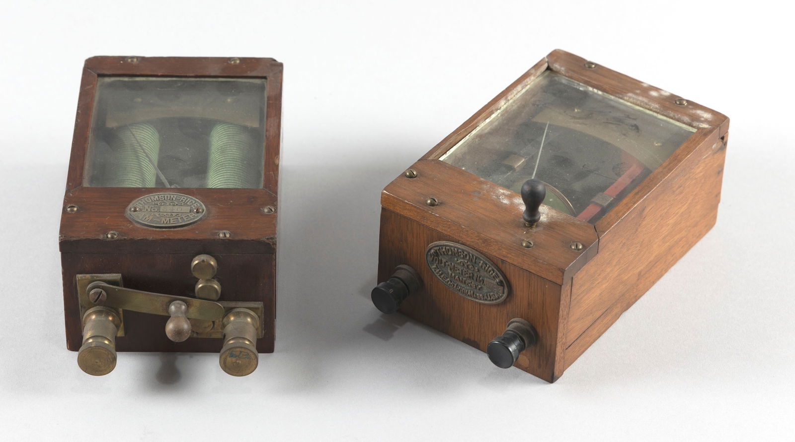 TWO THOMSON-RICE ELECTRIC METERS Late 19th Century: TWO THOMSON-RICE ELECTRIC METERSLate 19th Century1) Thomson-Rice voltmeter. Serial #1711. Marked on brass plaque "T.H.E. Co., Lynn, MA". Height 4". Length 7.5". Width 4.25".2) Thomson-Rice ammeter. De