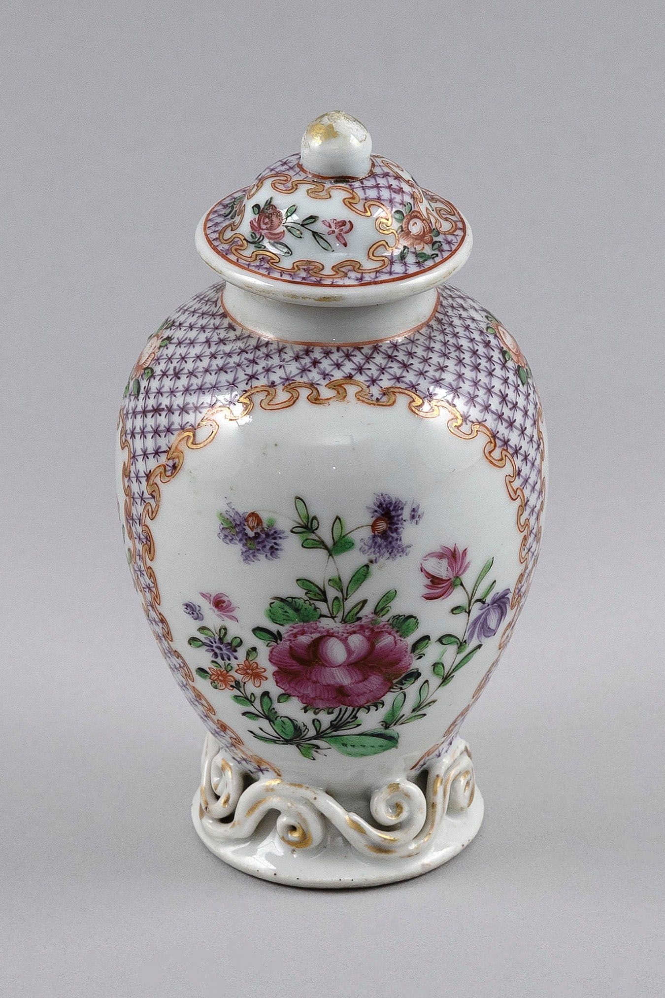 CHINESE EXPORT FAMILLE ROSE PORCELAIN TEA CADDY Late 18th/Early 19th Century Height 5.75".: CHINESE EXPORT FAMILLE ROSE PORCELAIN TEA CADDYLate 18th/Early 19th CenturyFloral cartouches with gilt scroll borders against a diapered ground. Sculpted scrolled foot.Height 5.75".