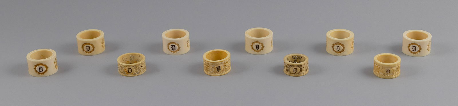 TEN CHINESE EXPORT CARVED AND ENGRAVED IVORY NAPKIN RINGS 19th Century: TEN CHINESE EXPORT CARVED AND ENGRAVED IVORY NAPKIN RINGS19th Century1-6) Set of six engraved "D" and with three relief-carved panels depicting Chinese subjects. Heights 1". Diameters 1.875".7-10) Thr
