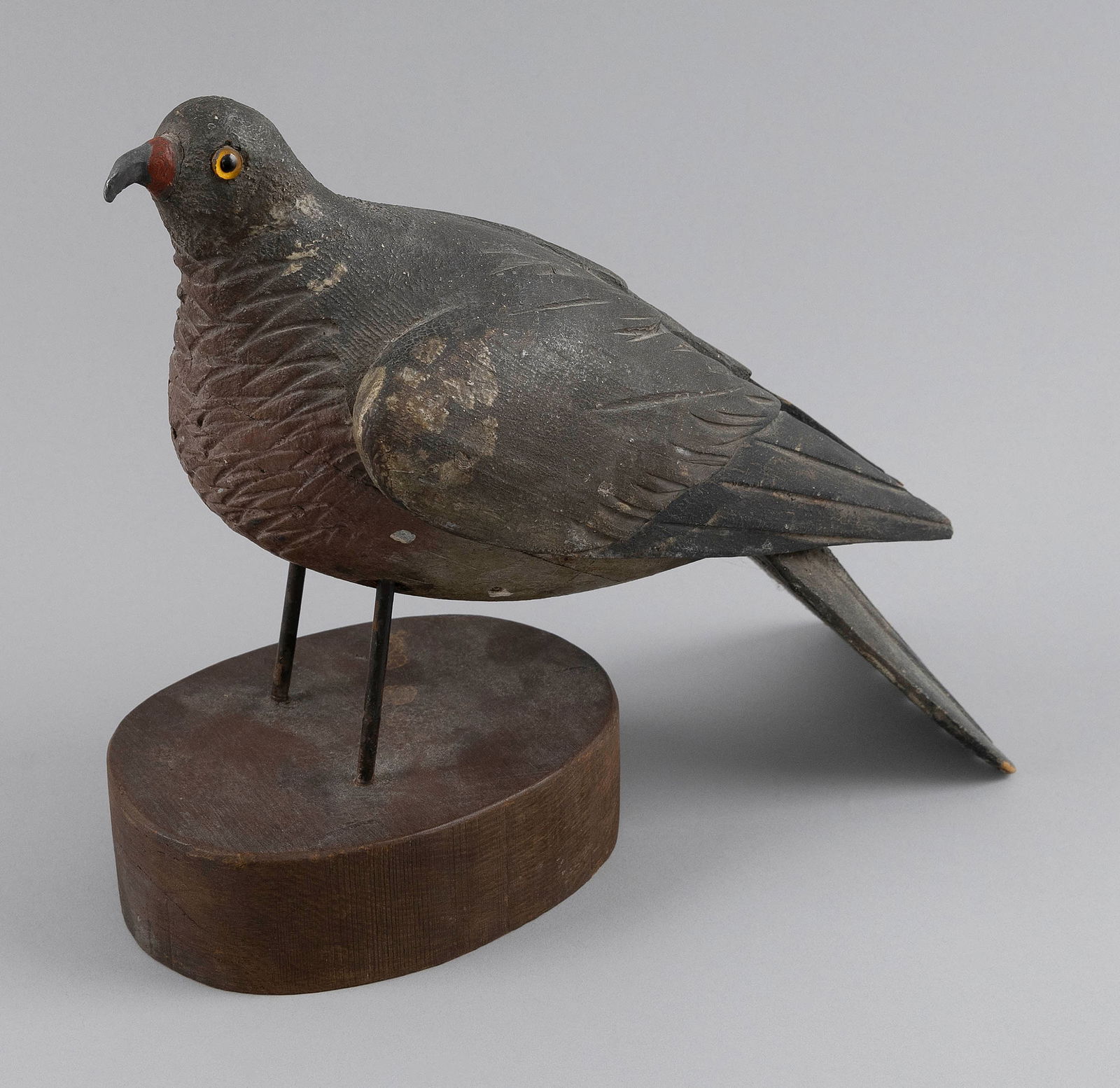 ENGLISH WOOD PIGEON DECOY Early 20th Century Height 10". Length 14".: ENGLISH WOOD PIGEON DECOYEarly 20th CenturyGlass eyes. Carved wings and tail. Mounted on a wooden base. Signed under tail "C.C.R - EH".Height 10". Length 14".