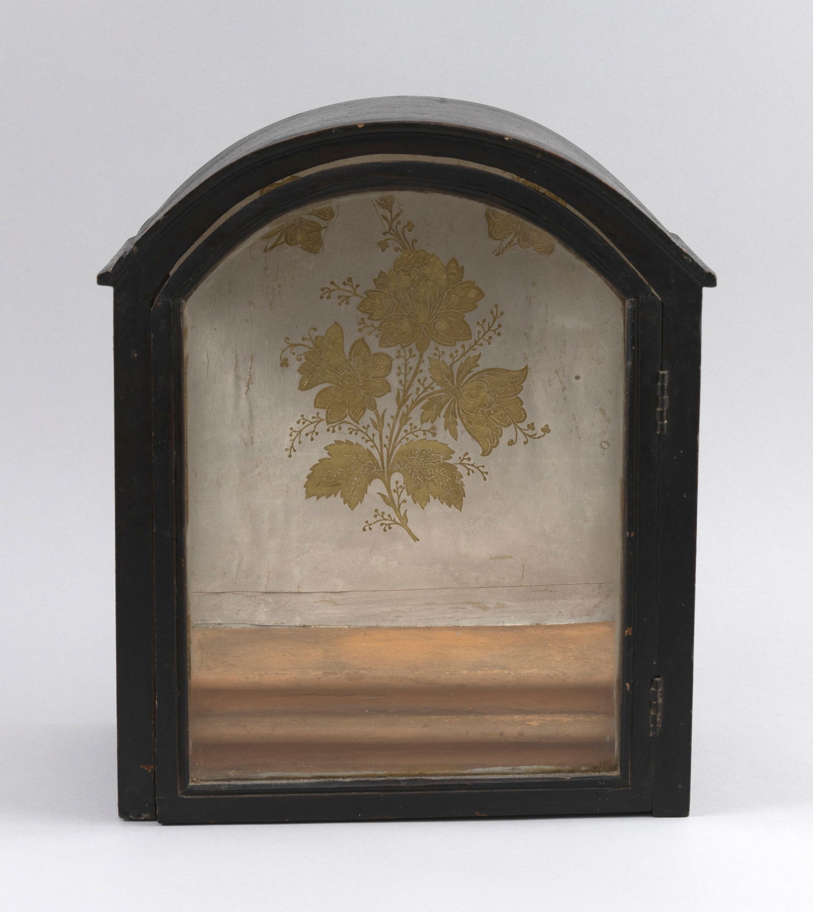 DOMED DISPLAY CASE Early 19th Century Height 11.5". Width 10". Depth 5.5".: DOMED DISPLAY CASEEarly 19th CenturyPine under a dark stain showing fine patina. Stepped interior, the backboard with gilt floral decoration.Height 11.5". Width 10". Depth 5.5". Provenance:The Coll