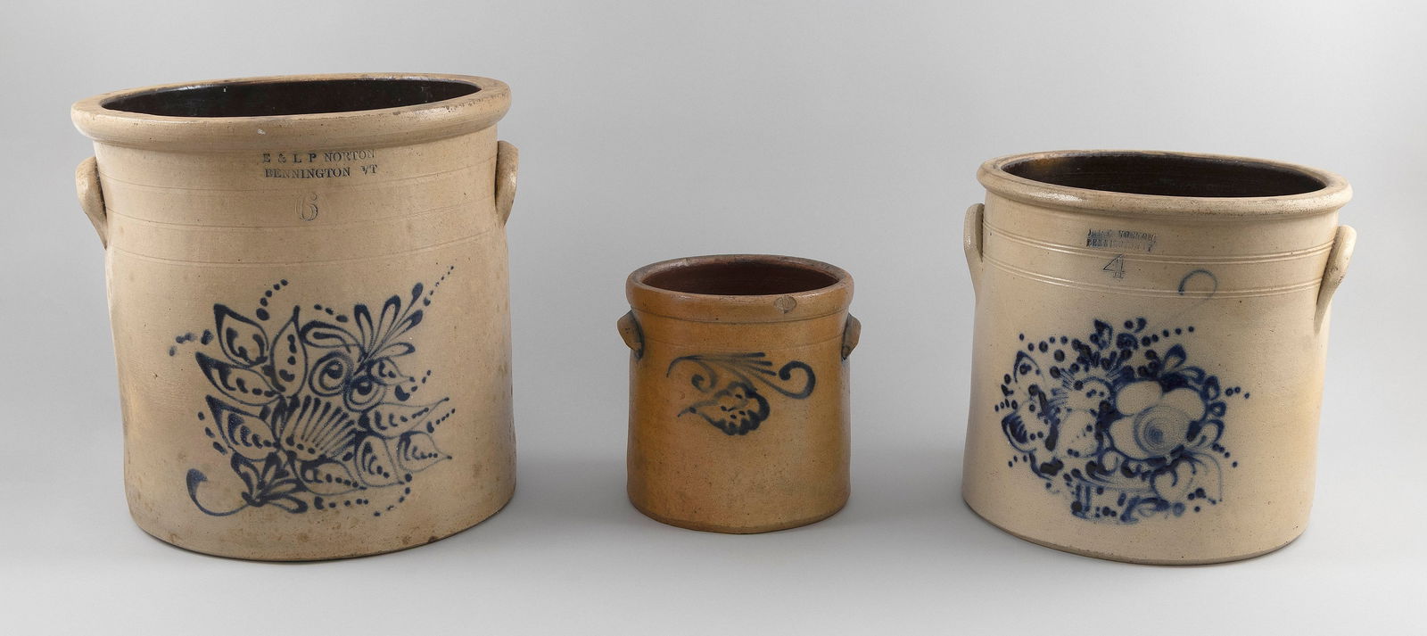 THREE STONEWARE CROCKS 19th Century Heights from 8" to 13.5".: THREE STONEWARE CROCKS19th CenturyAn E. & L.P. Norton six-gallon, a Norton four-gallon and one unmarked. All with cobalt blue floral decoration.Heights from 8" to 13.5".