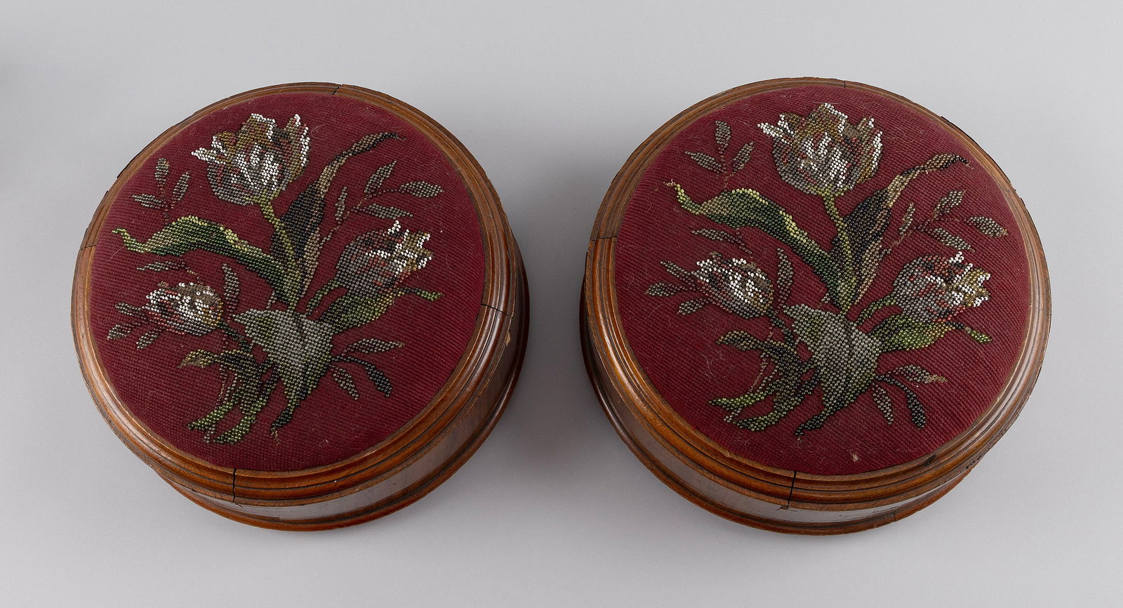 PAIR OF LOW FOOT STOOLS 19th Century Heights 5.5". Diameters 11.75".: PAIR OF LOW FOOT STOOLS19th CenturyWalnut and walnut veneer with needlework tops in a floral design. Three small ball feet.Heights 5.5". Diameters 11.75".