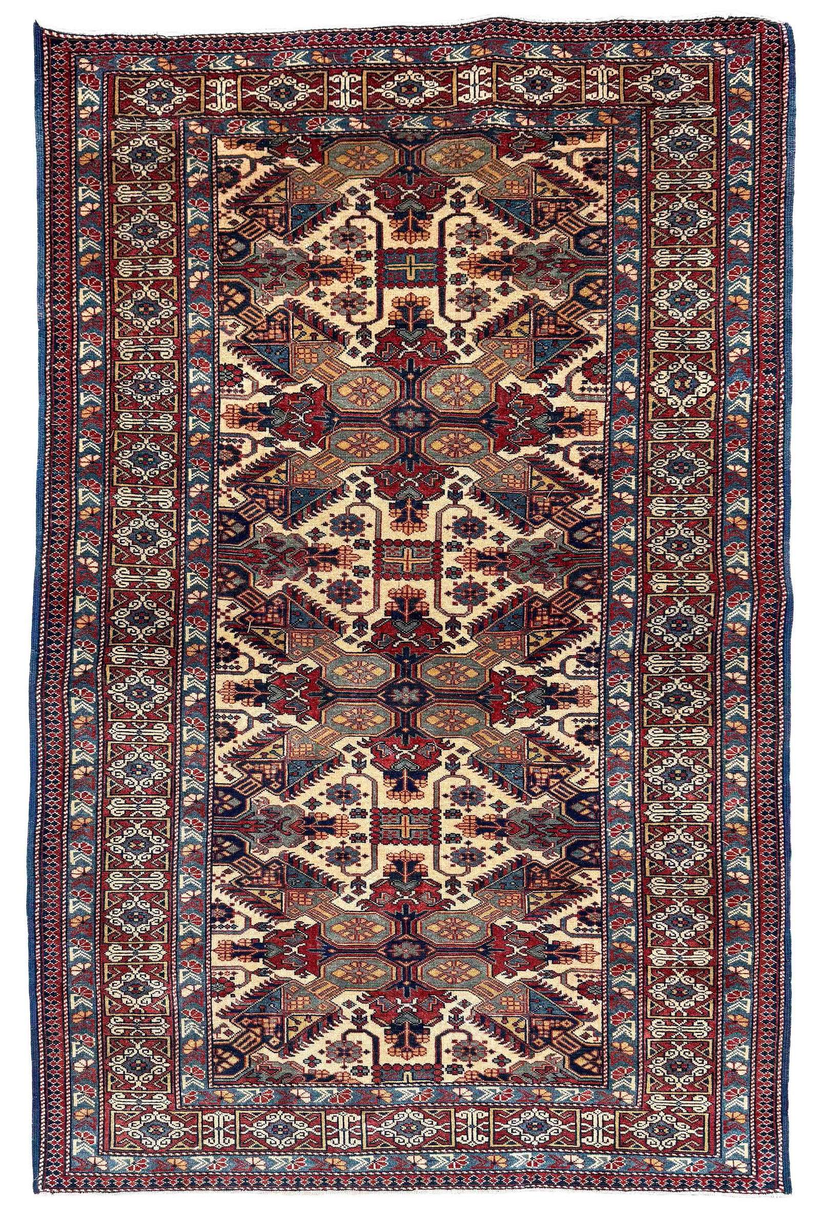 SEICHOR DESIGN RUG: 4'2" X 5'0" Late 20th Century: SEICHOR DESIGN RUG: 4'2" X 5'0"Late 20th CenturyDark ivory field contains bold cruciform motifs in dark red, light blue, navy blue and gold. Slate blue guard borders. Deep crimson main border with Kuf