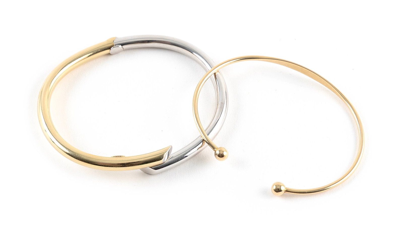 TWO 14KT GOLD BANGLE BRACELETS Approx. 13.0 total dwt.: TWO 14KT GOLD BANGLE BRACELETS1) White and yellow gold bypass design. Hinged. Width approx. 5.0mm. Length 7".2) Yellow gold. Tapers from approx. 3.5 to 2.0mm. Ends with two approx. 5.0mm gold balls. L