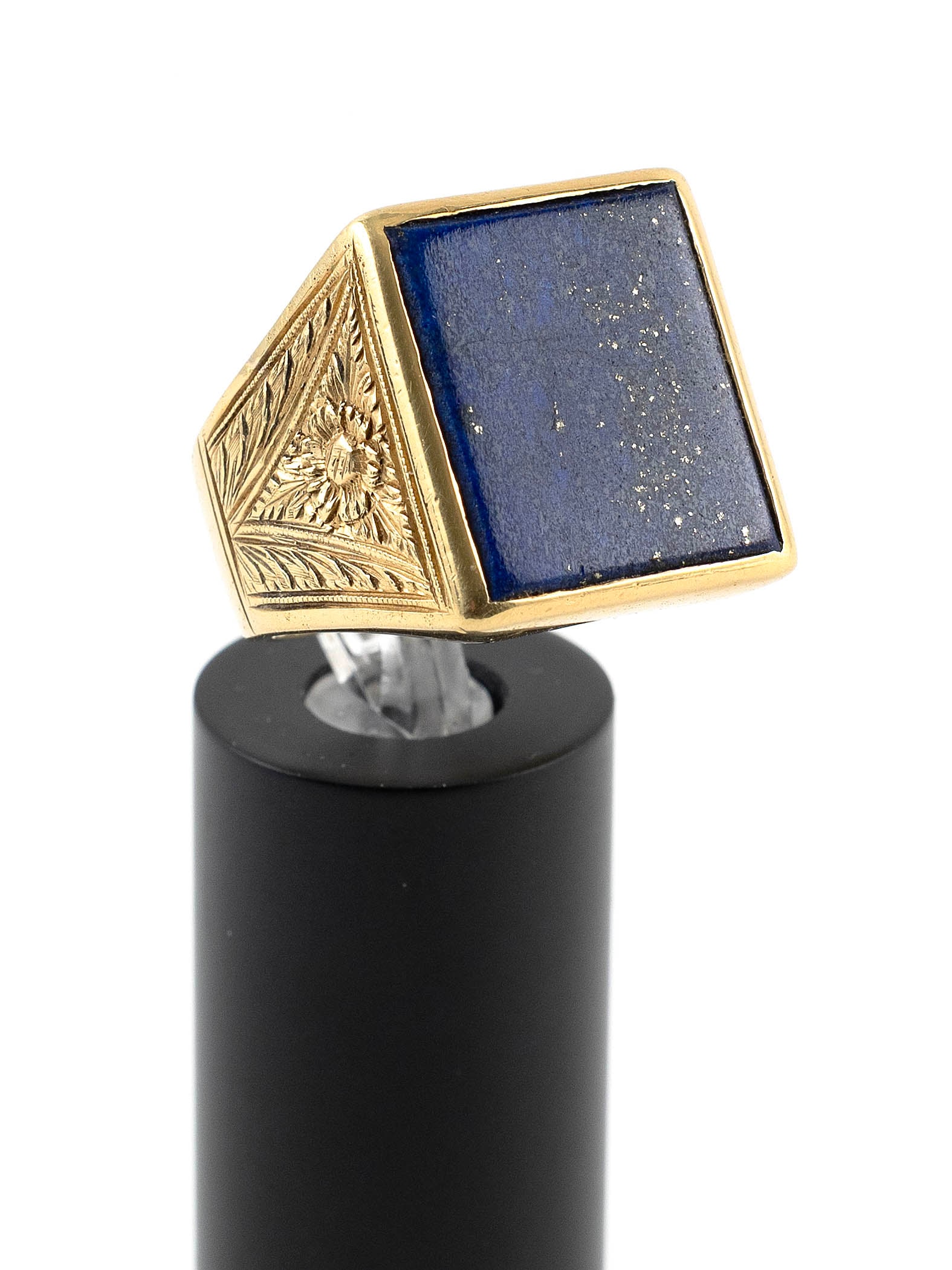 18KT YELLOW GOLD AND LAPIS LAZULI RING Approx. 16.7 total dwt.: 18KT YELLOW GOLD AND LAPIS LAZULI RINGOne approx. 15.0 x 18.0mm lapis lazuli. Tapers from approx. 20.0 to 6.0mm. Sides with engraved design. Size 10?.Approx. 16.7 total dwt. Provenance:The Estate of H
