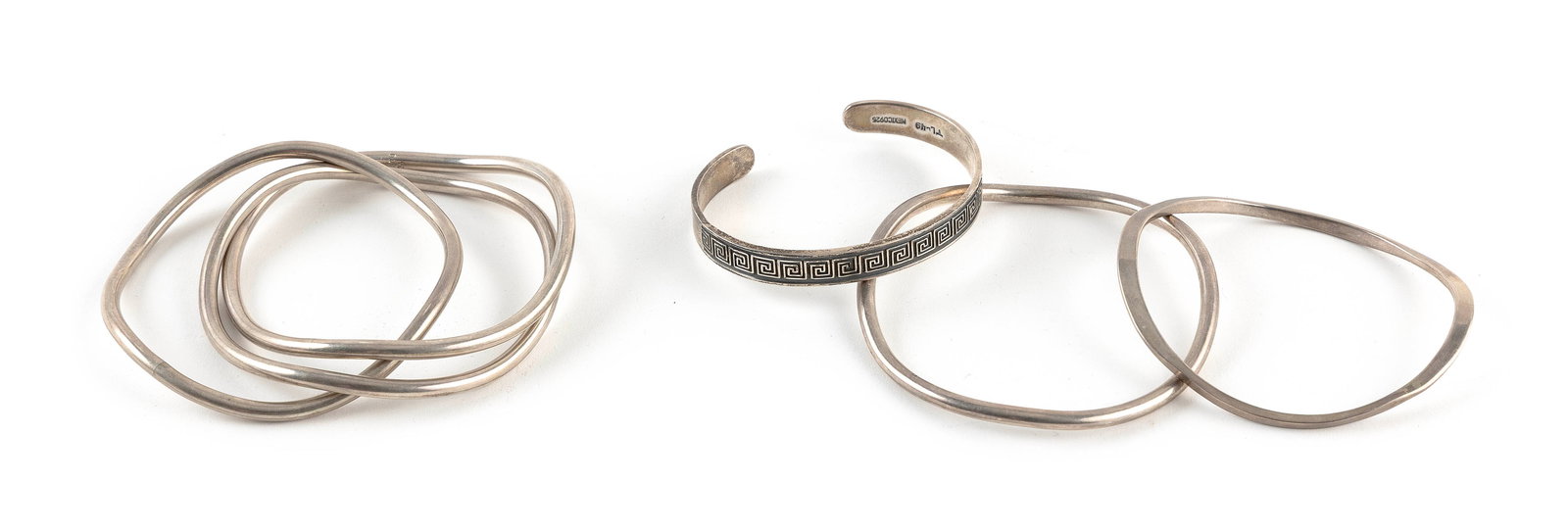 FOUR STERLING SILVER BANGLE BRACELETS Approx. 58.5 total dwt.: FOUR STERLING SILVER BANGLE BRACELETS1) Cuff with Greek key design. Width approx. 8.0mm. Length 7".2) Contemporary style. Width approx. 4.0mm. Length 8".3) Contemporary style. Width approx. 3.0mm. Len