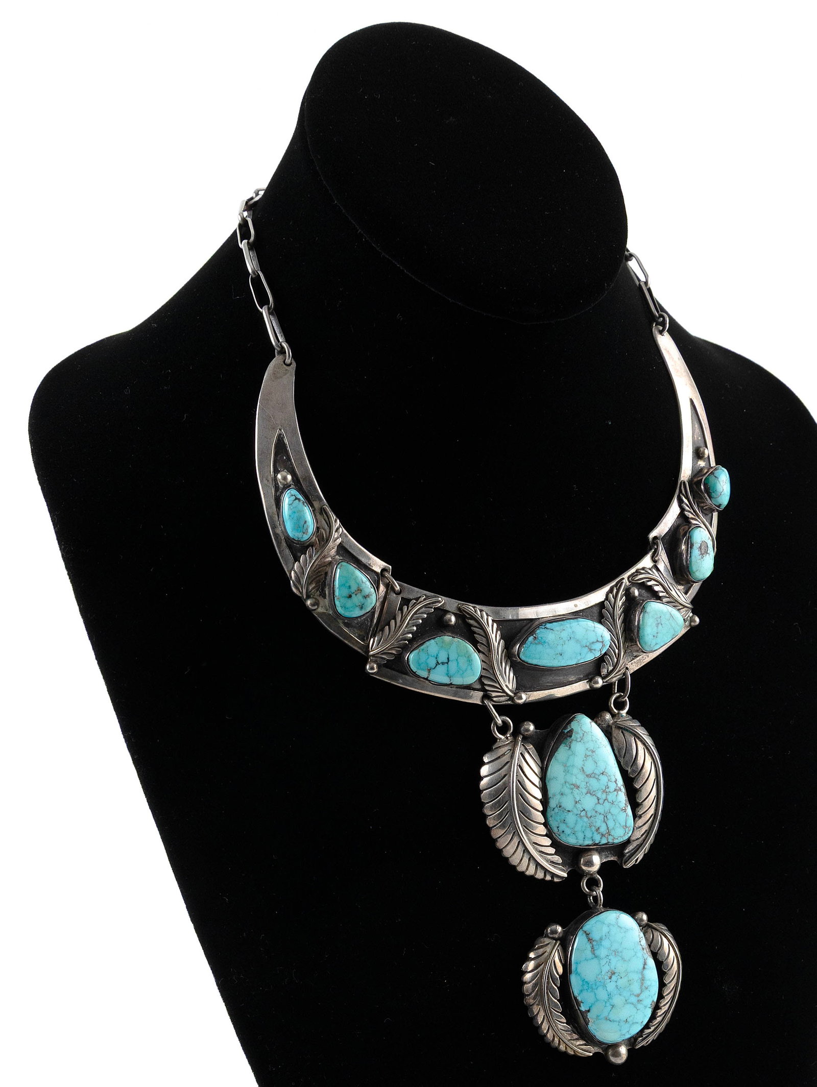 ALICE PLATERO NAVAJO SILVER AND TURQUOISE CHOKER NECKLACE Mid-20th Century Approx. 106 grams: ALICE PLATERO NAVAJO SILVER AND TURQUOISE CHOKER NECKLACEMid-20th CenturyTwo drop pendants with polished turquoise nuggets between feather and bead decorations. Stamped artist's mark on the lower drop