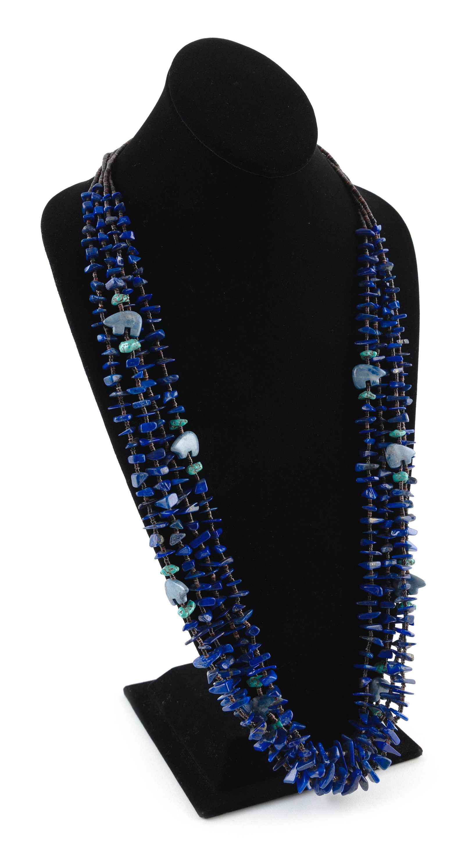 JOANNE TENORIO SANTO DOMINGO PUEBLO NAVAJO FETISH NECKLACE Late 20th Century Approx. 170 grams: JOANNE TENORIO SANTO DOMINGO PUEBLO NAVAJO FETISH NECKLACELate 20th CenturyFour strands of polished lapis lazuli nuggets spaced with heishi shell beads and carved bear-form fetishes. Silver cone clasp