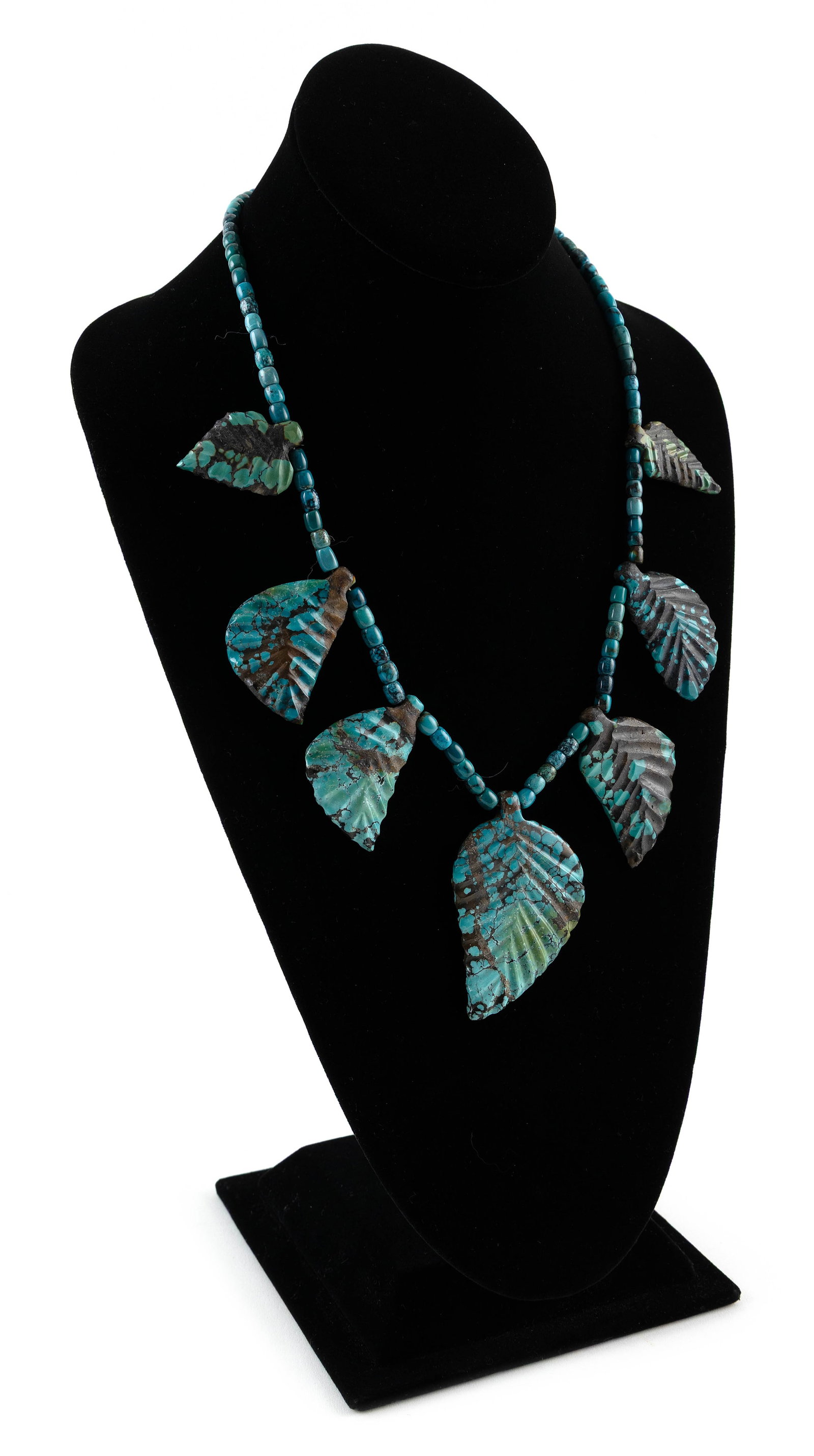 SARAH LUKYA NAVAJO CARVED TURQUOISE LEAF NECKLACE Late 20th Century Approx. 99.6 grams: SARAH LUKYA NAVAJO CARVED TURQUOISE LEAF NECKLACELate 20th CenturySeven carved turquoise leaves and polished rounded beads. Silver clasp. Length 21".Approx. 99.6 grams Provenance:Purchased directly