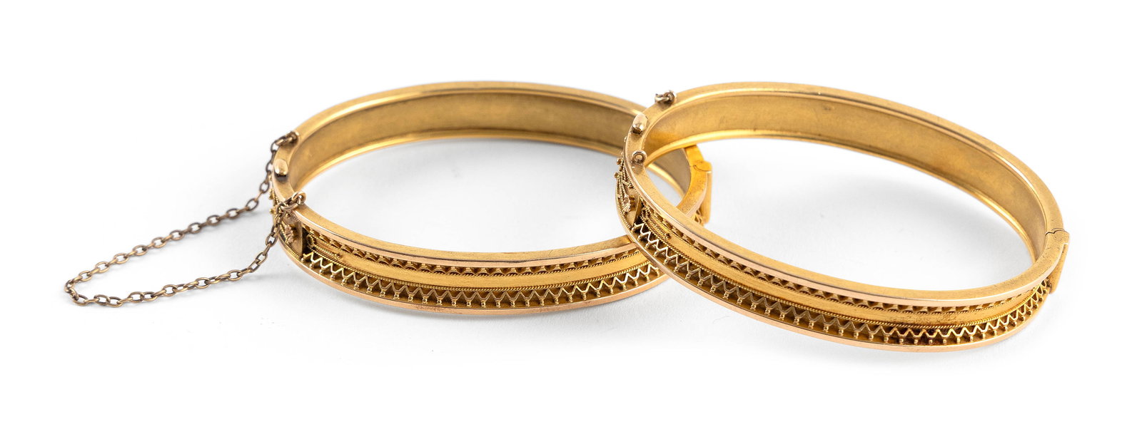 PAIR OF 14KT YELLOW GOLD BANGLE BRACELETS Approx. 19.6 total dwt.: PAIR OF 14KT YELLOW GOLD BANGLE BRACELETSHinged with box clasp. One with safety chain. Widths approx. 9.0mm. Lengths 7".Approx. 19.6 total dwt.