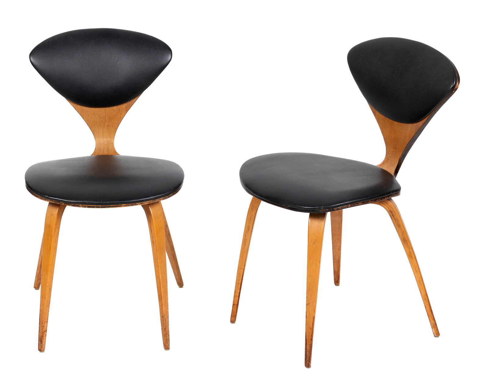 PAIR OF NORMAN CHERNER (NEW YORK, 1920-1987) FOR PLYCRAFT WALNUT SIDE CHAIRS Circa 1960 Back heights: PAIR OF NORMAN CHERNER (NEW YORK, 1920-1987) FOR PLYCRAFT WALNUT SIDE CHAIRSCirca 1960Back and seat pads with black leather upholstery. Both with Plycraft labels. One with partial Textile Products Ide