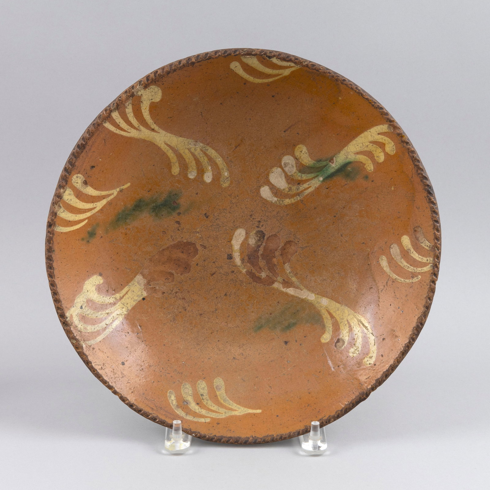 PENNSYLVANIA SLIP-DECORATED SHALLOW BOWL Late 18th/Early 19th Century Diameter 12".: PENNSYLVANIA SLIP-DECORATED SHALLOW BOWL Late 18th/Early 19th Century Tan, yellow and green decoration. Rope-style rim. Diameter 12". Provenance: The Estate of Paul and Diane Madden, Sandwich, Massach