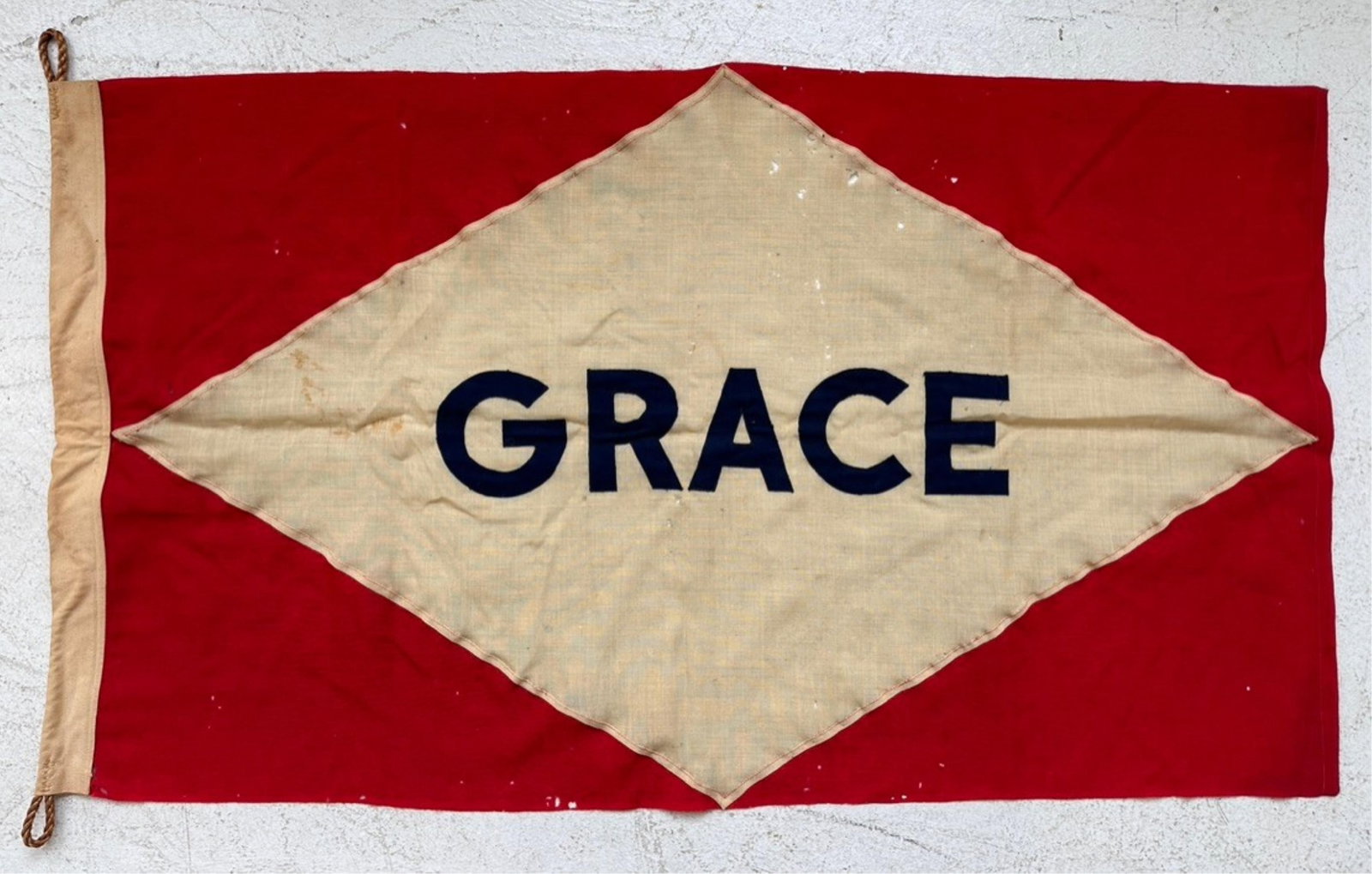 GRACE STEAMSHIP LINE LINEN BUNTING FLAG Early 20th Century 27" x 30".: GRACE STEAMSHIP LINE LINEN BUNTING FLAG Early 20th Century "Grace" stitched lettering in a white diamond on a red field. The Grace shipping line dominated the shipping trade between New York and the w