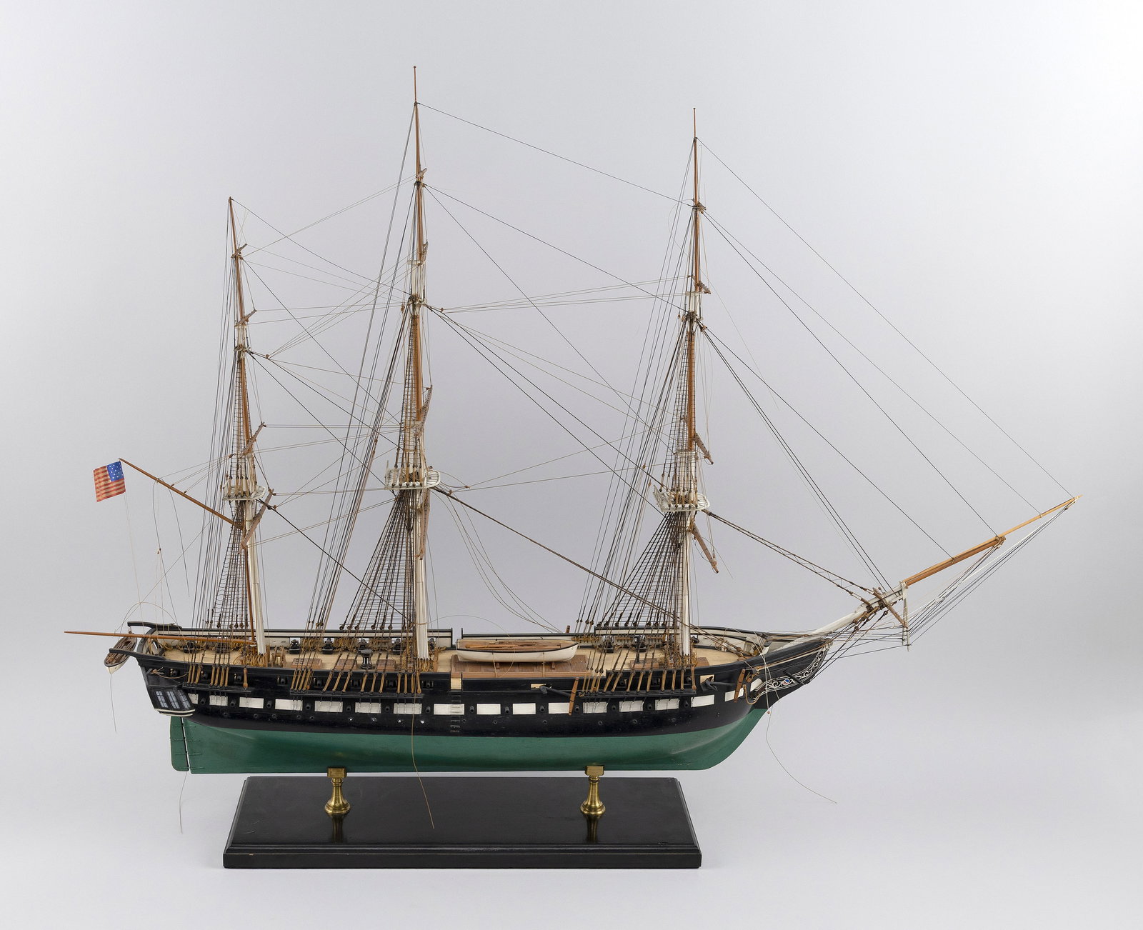 MODEL OF U.S.S. "CONSTITUTION" 20th Century Height 28". Width 8".: MODEL OF U.S.S. "CONSTITUTION" 20th Century Black hull with green bottom. Rigged and nicely outfitted. Displayed on pedestals on a painted wood base. Height 28". Width 8".