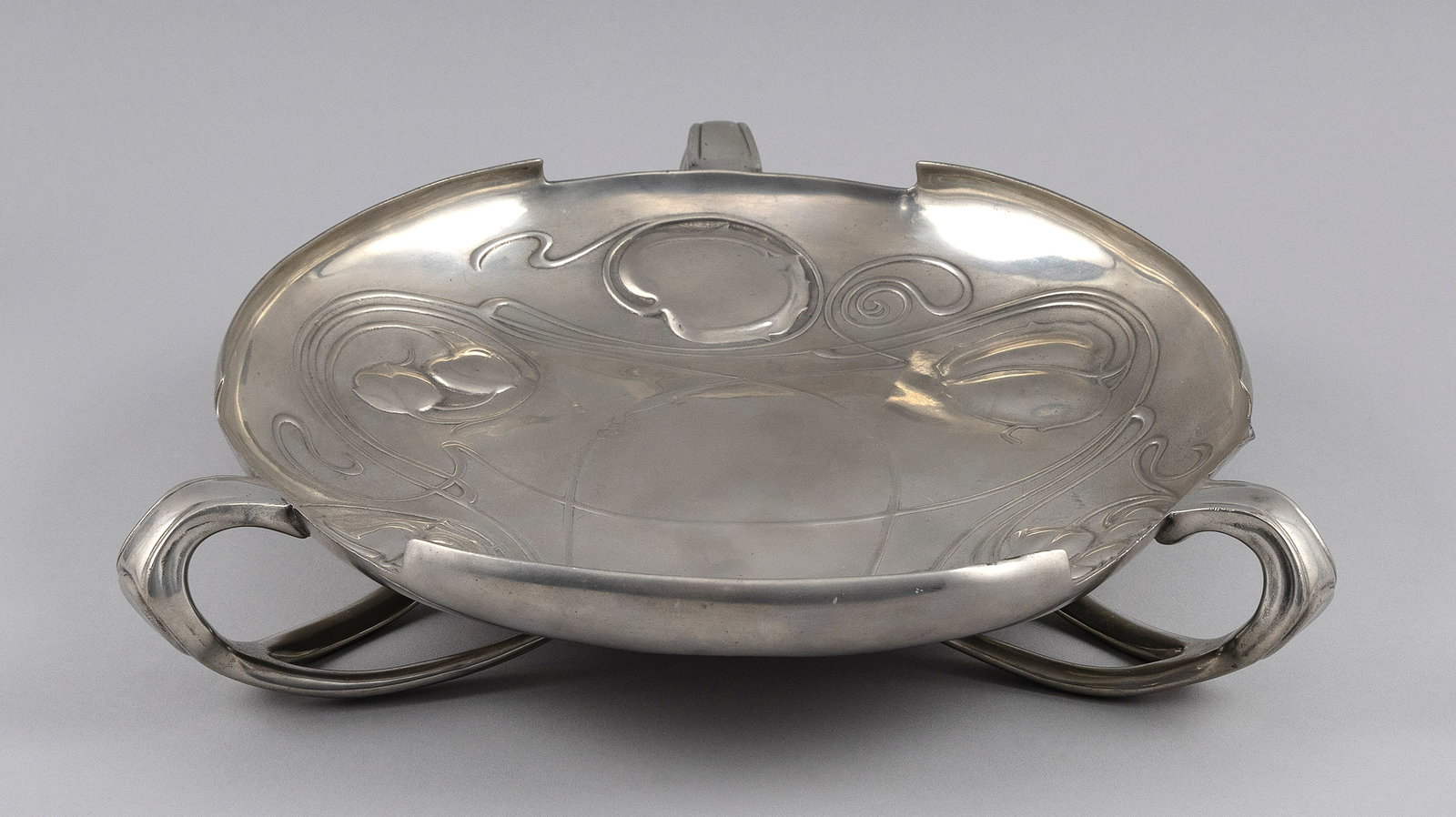 ARCHIBALD KNOX FOR LIBERTY & CO. LTD. "THE BOLLELIN" PEWTER TRAY London, Late 19th/Early 20th: ARCHIBALD KNOX FOR LIBERTY & CO. LTD. "THE BOLLELIN" PEWTER TRAY London, Late 19th/Early 20th Century With three handles and an Art Nouveau leaf and tendril design. Marked on base "English Pewter" and