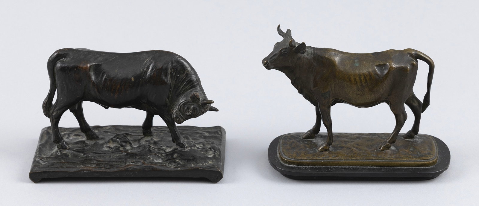 TWO CONTINENTAL BRONZE BULLS Late 19th/Early 20th Century: TWO CONTINENTAL BRONZE BULLS Late 19th/Early 20th Century 1) On a rectangular base. Marked "Made in Austria". Height 3.5". Length 5.25". 2) On a rounded rectangular slate base. Unmarked. Height 4.25".